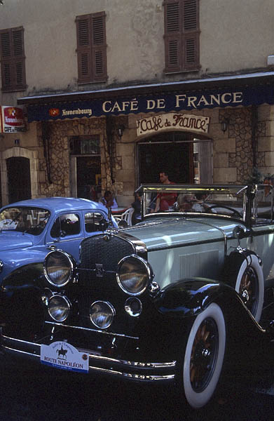 A 1920s Chevrolet roadster dwarfs a Renault 4CV in Vallauris.